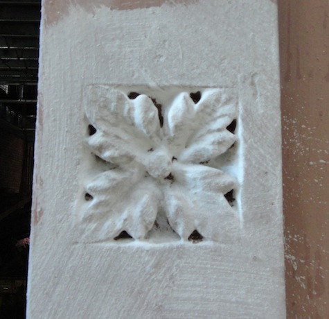 Restoring rosette in brownstone façade